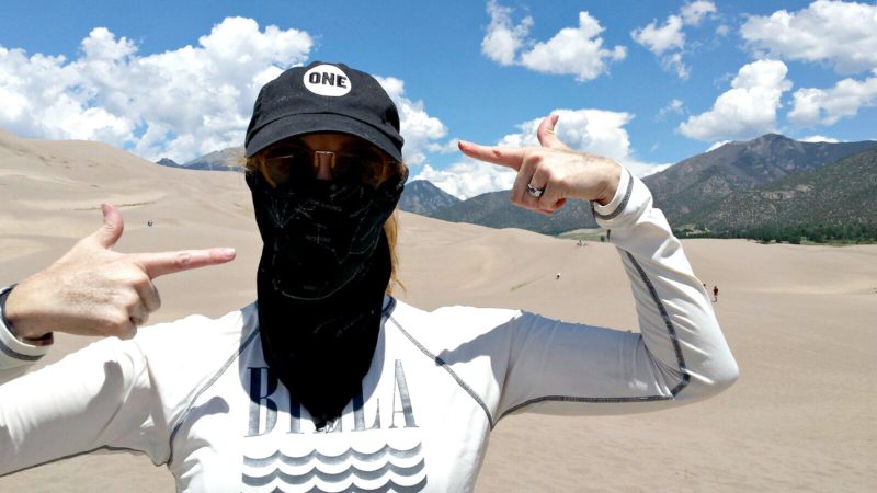woman in hat and bandanna on sand dunes