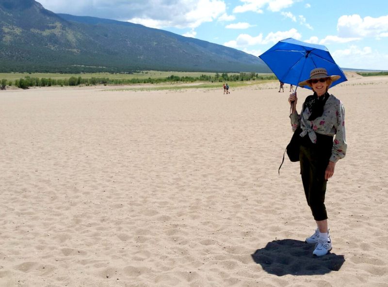woman with umbrella on sand dunes