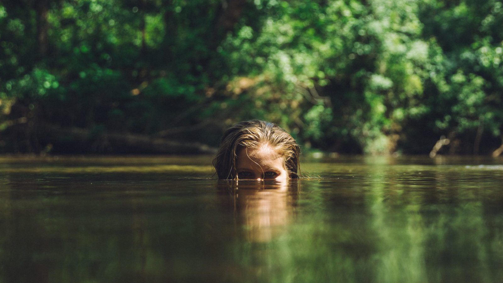 girl with eyes above water