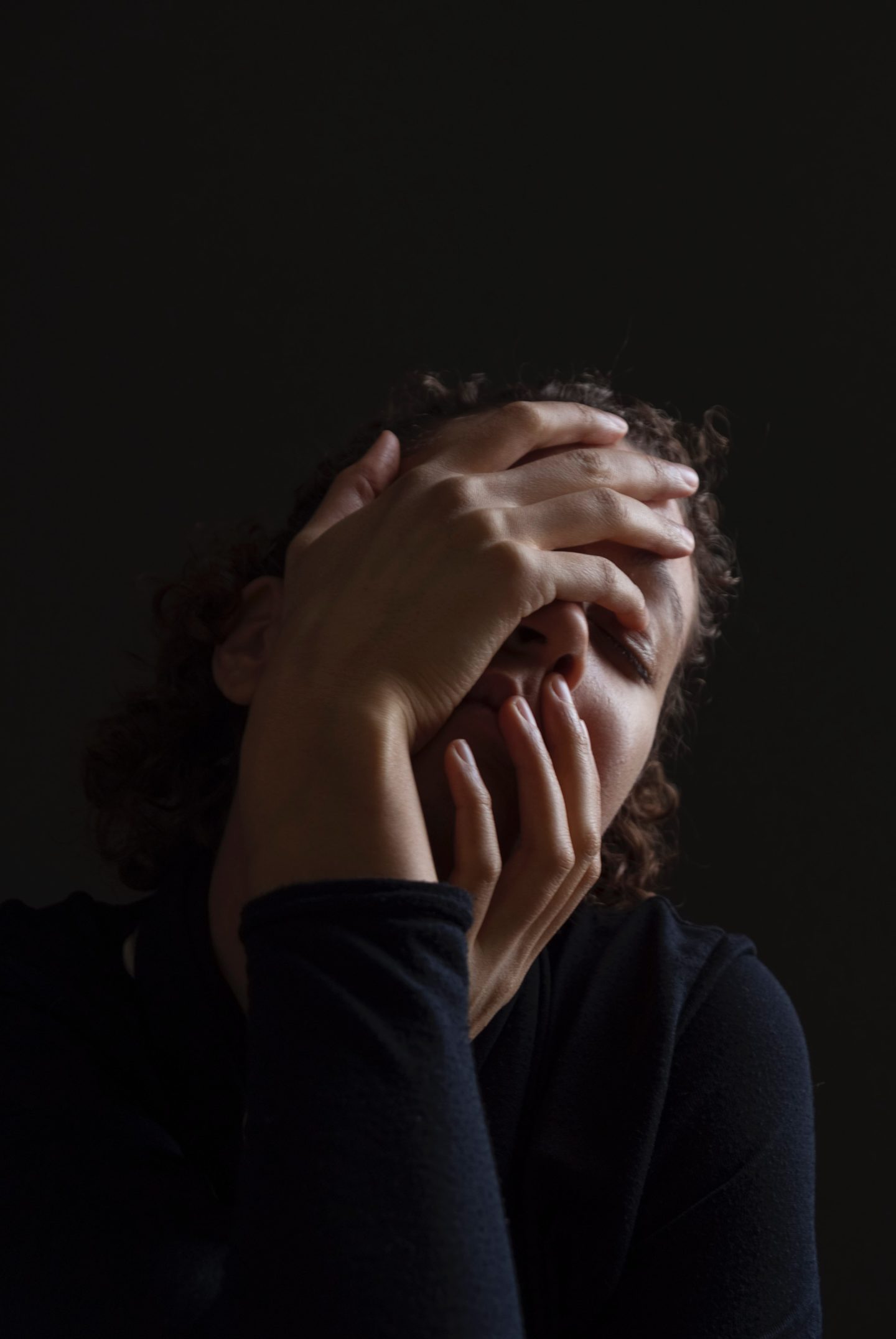 woman clasping face